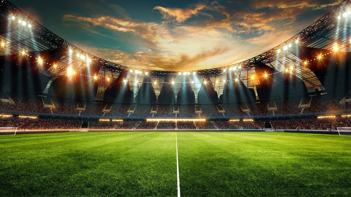 Estadio de fútbol moderno con gradas iluminadas