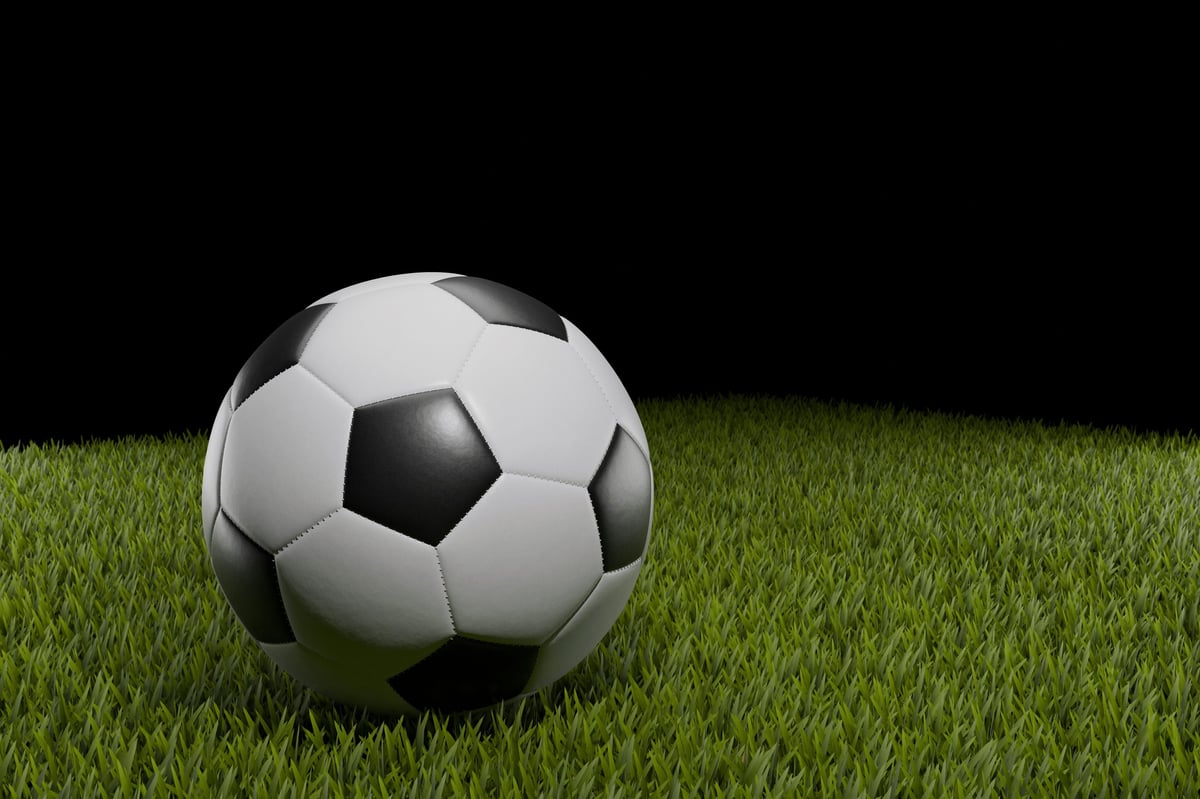 Balón de fútbol sobre césped verde