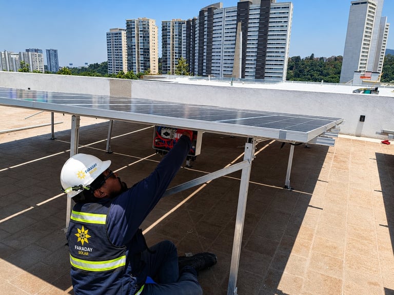 Técnico certificado por CONOCER instalando panel solar en azotea con edificios de la ciudad de fondo