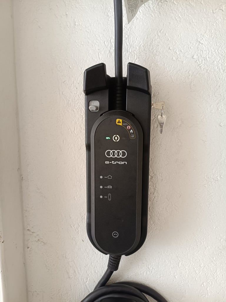 Cable de carga de auto eléctrico Audi e-tron con unidad de control montada en pared blanca